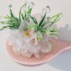 this small wall-hanging sculpture features vintage silk flowers dipped in resin and adhered to a rounded